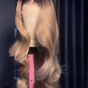 Perruque Lace HD blonde champagne avec longues ondulations glamour et racines foncées.